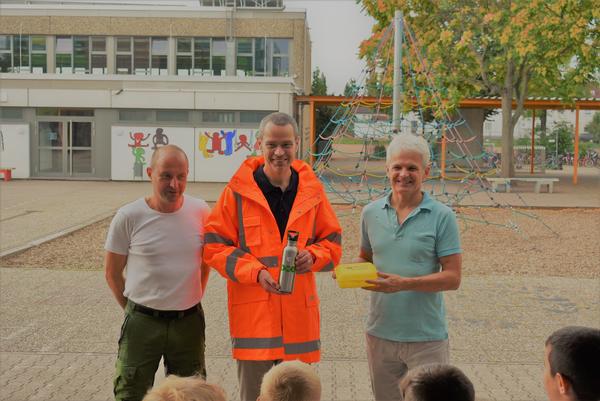 Bild vergr��ern: BGM Dr. Ingenthron, in einer Jacke der M�llabfuhr, bei der Trinkflaschen�bergabe