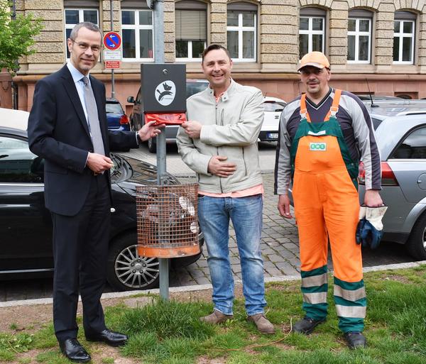 Bild vergr��ern: Landaus Innenstadt nun mit Hundekotbeutelspendern, hier in der Langstra�e. V.l.n.r.: Verwaltungsratsvorsitzender Dr. Maximilian Ingenthron, Vorstand Falk Pfersdorf und Bauhofmitarbeiter Christian Meyer vor Ort.