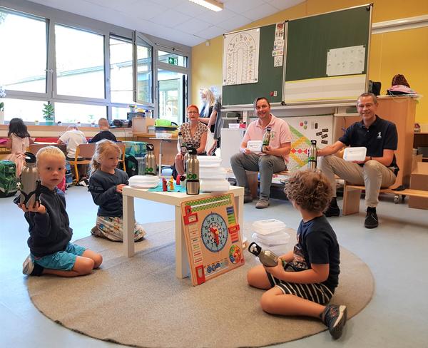 Bild vergr��ern: Mit stabilen Brotdosen und sind die J�ngsten in Landau f�r den Schulstart ger�stet. V.l.n.r.: Konrektorin Susanne Roth, Vorstandsmitglied Falk Pfersdorf und B�rgermeister Dr. Ingenthron �bergaben dieses Starter-Kit den Schulanf�ngern der Igelklasse in der Grundschule S�d.