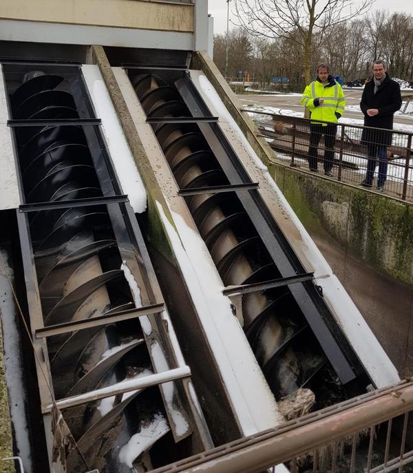 Bild vergr��ern: Volle Redundanz sichern die beiden Schnecken am Zulauf der Kl�ranlage. Das Foto zeigt die neu eingesetzte Schnecke links, w�hrend die alte rechts ganze Arbeit leistet. V.l.n.r: Herr Dr. Markus Sch�fer gemeinsam mit Dr. Maximilian Ingentron bei der Begutachtung der neuen beiden Schnecken. Inzwischen ist die gesamte Anlage erneuert - dazu hat der EWL kr�ftig investiert. Ziel sind ein moderner und ab 2023 ein klimaneutraler Betrieb der Landauer Abwasserreinigung.