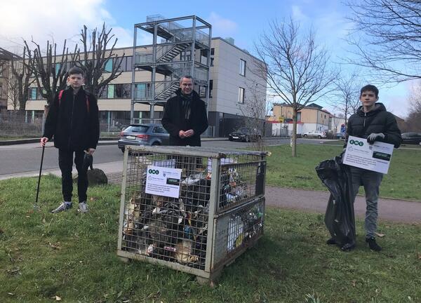 Bild vergr��ern: Gut gef�llt war die Gitterbox mit eingesammelten Abf�llen Mitte M�rz. Carlos Log� (links), Dr. Maximilian Ingenthron (Mitte) und Louis Hess (rechts) sch�tzen, dass der Beh�lter bis Ende M�rz voll ist. Denn mit der Fr�hlingssonne landen leider auch mehr Papier und andere Verpackungen in den Gr�nanlagen.